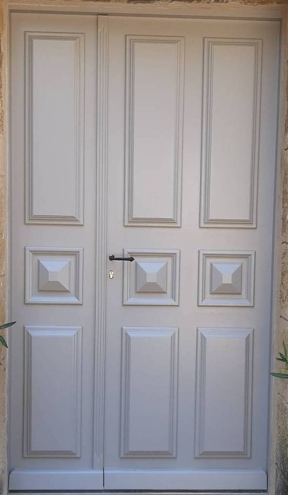 Fabrication d'une porte d'entrée sur mesure en bois exotique rouge à panneaux moulurés à Rognes près d'Aix en Provence